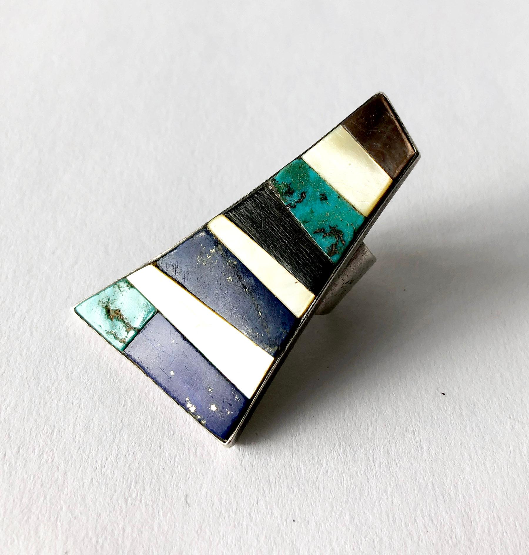 Carmelo Patania turquoise, ebony, lapis lazuli and shell mosaic layered in a trapezoidal frame of sterling silver.  Ring is a finger size 6.5 to 6.75.  Face of the ring measures 2 1/4