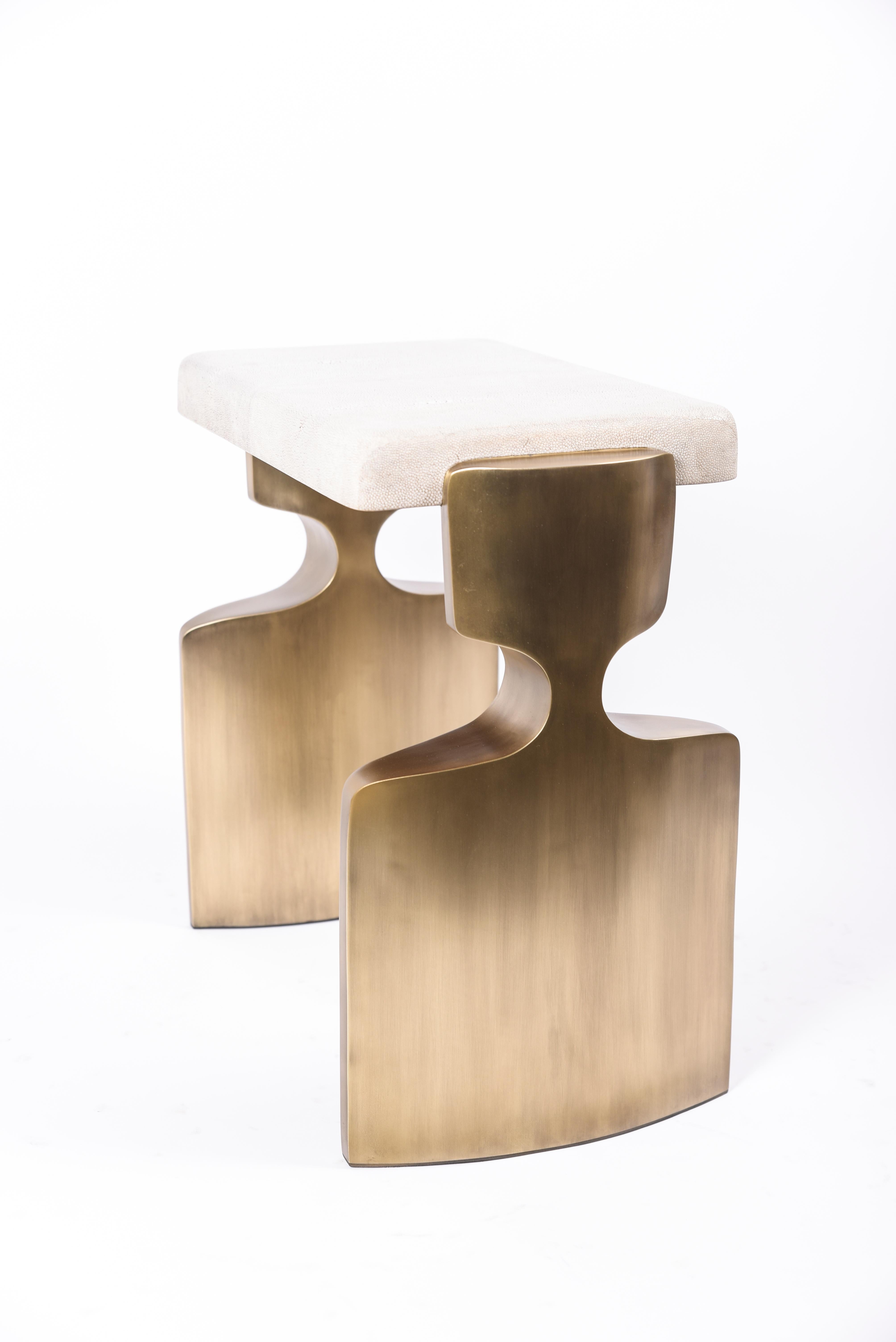 The Carmen stool is a stunning seating piece. The cream shagreen inlaid top sits on a pair of sculptural bronze-patina brass legs that frame the piece. Custom color/sizing available on request. A bench version is also available, image at end of