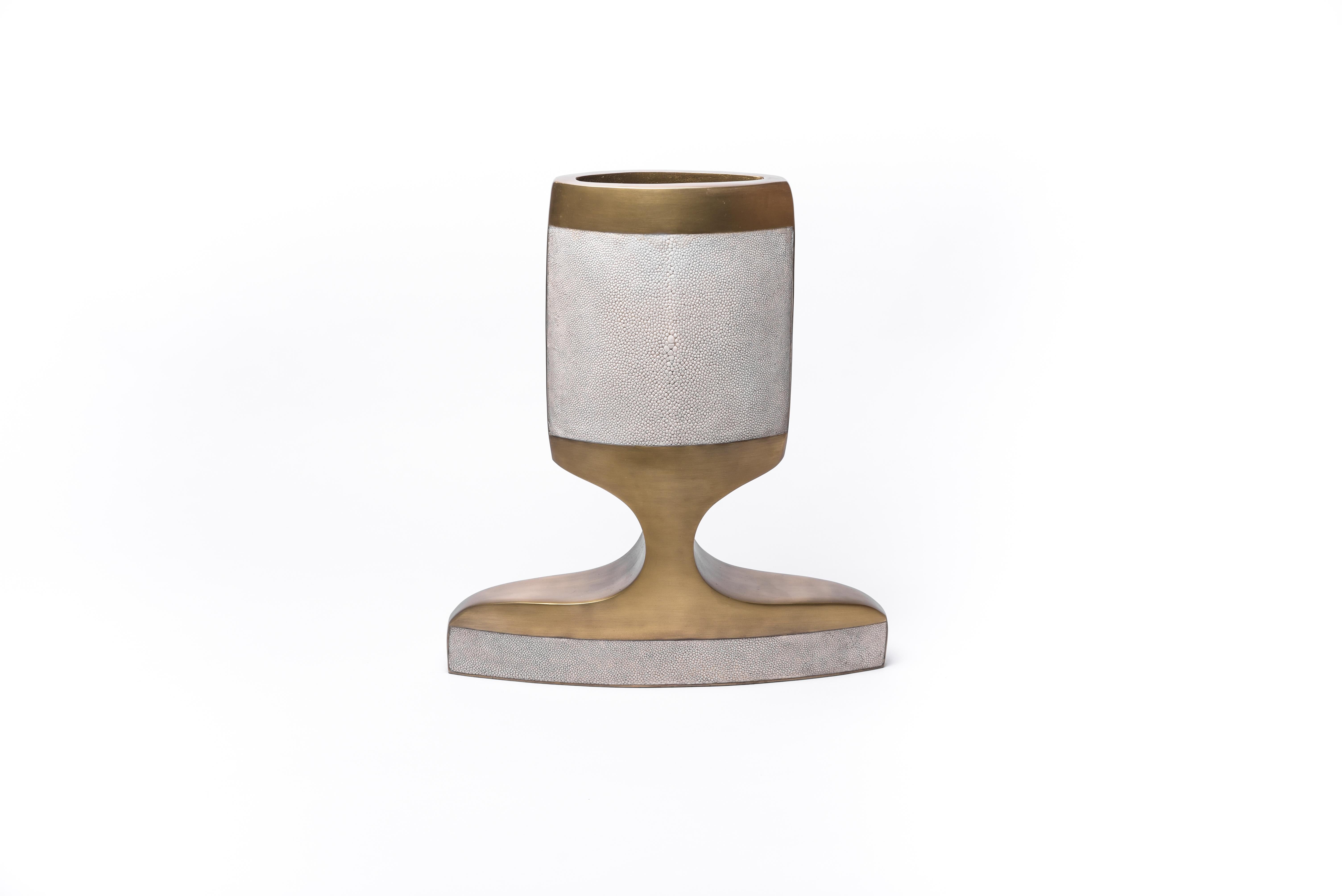 The medium Carmen vase is a sculptural piece creating a dramatic statement in any room. This vase is inlaid in a mixture of cream shagreen and bronze-patina brass.

· Shagreen/Pen Shell/Baguio Stone/Bronze-Patina Brass, fiber glass interior to