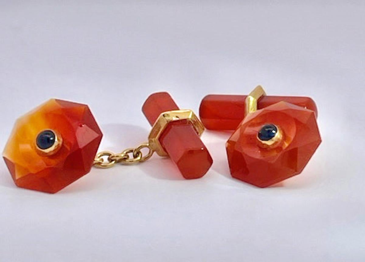 These lovely Carved Carnelian cufflinks are simple yet elegant.  They measure 20 mm x 5 mm baton, front is 12 mm x 12 mm and carved like a flower petal with a Sapphire cabochon center.  Made in Italy of 18K yellow gold beautifully constructed. 6.4