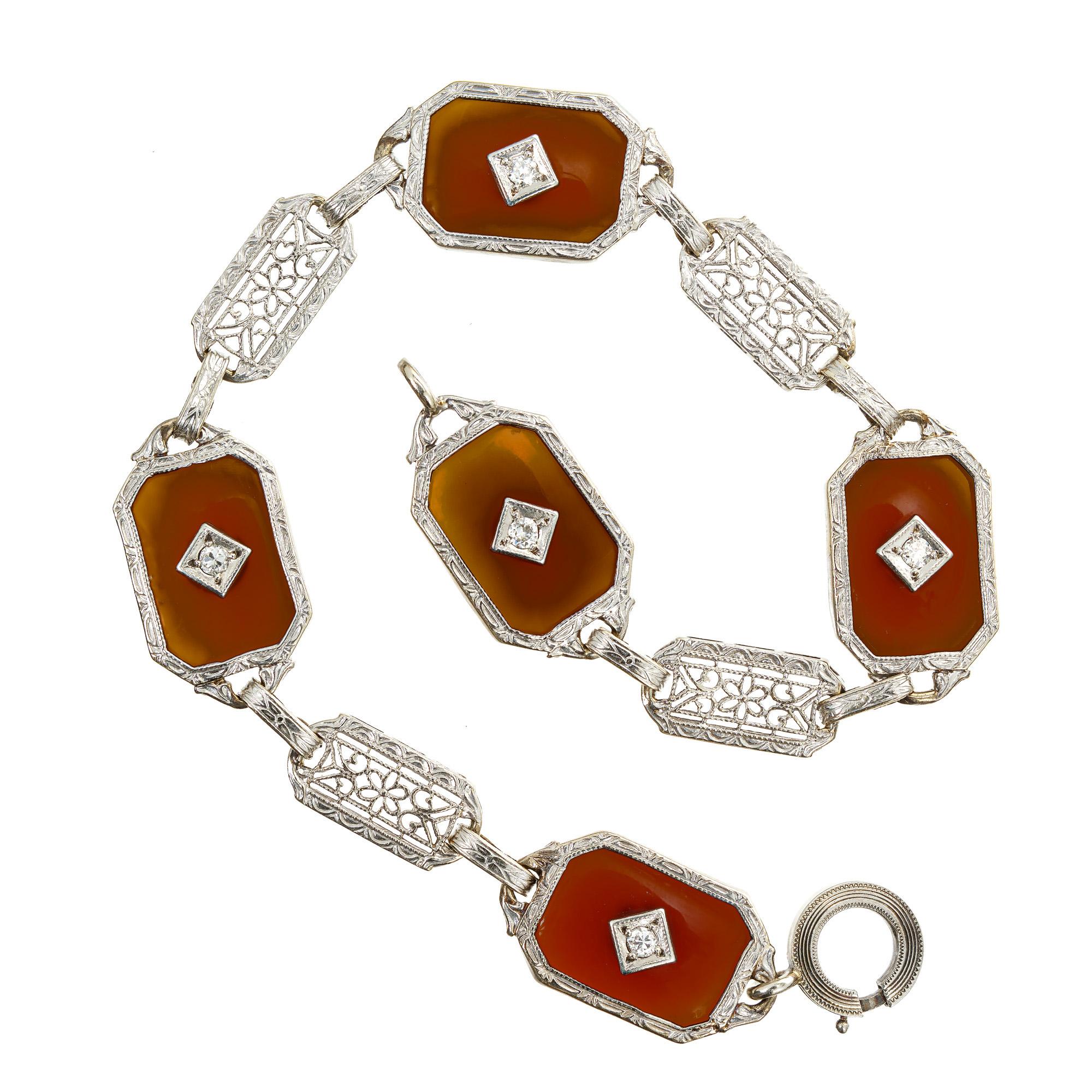 Carnelian diamond filigree 14k white gold bracelet. 5 round full cut diamonds set in 5 translucent brown carnelians. 7.25 inches in length.  Circa 1930-1940.

5 round full cut diamonds, approx. total weight .20cts, G, VS
5 translucent brown