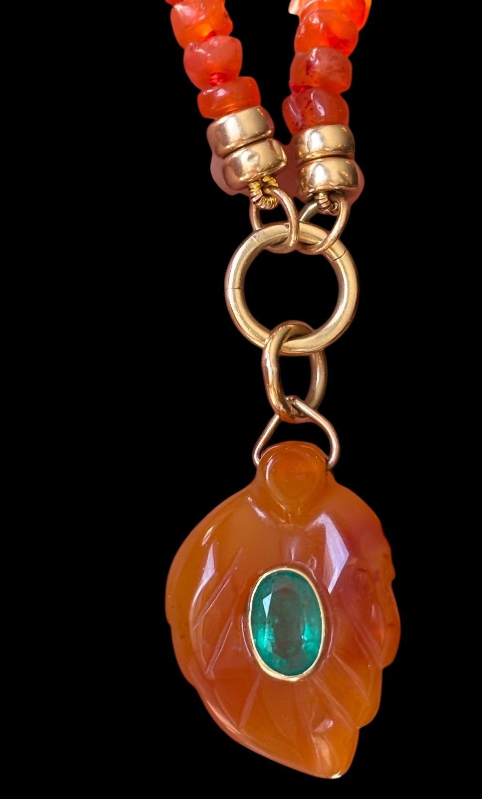 Collana di corniole e smeraldi 

Questa bellissima collana unica nel suo genere ha un ciondolo a forma di foglia di corniola intagliata (30x26 mm, esclusa la cauzione) con uno splendido smeraldo ovale centrale di 8x5 mm incastonato in oro 14k. 

La