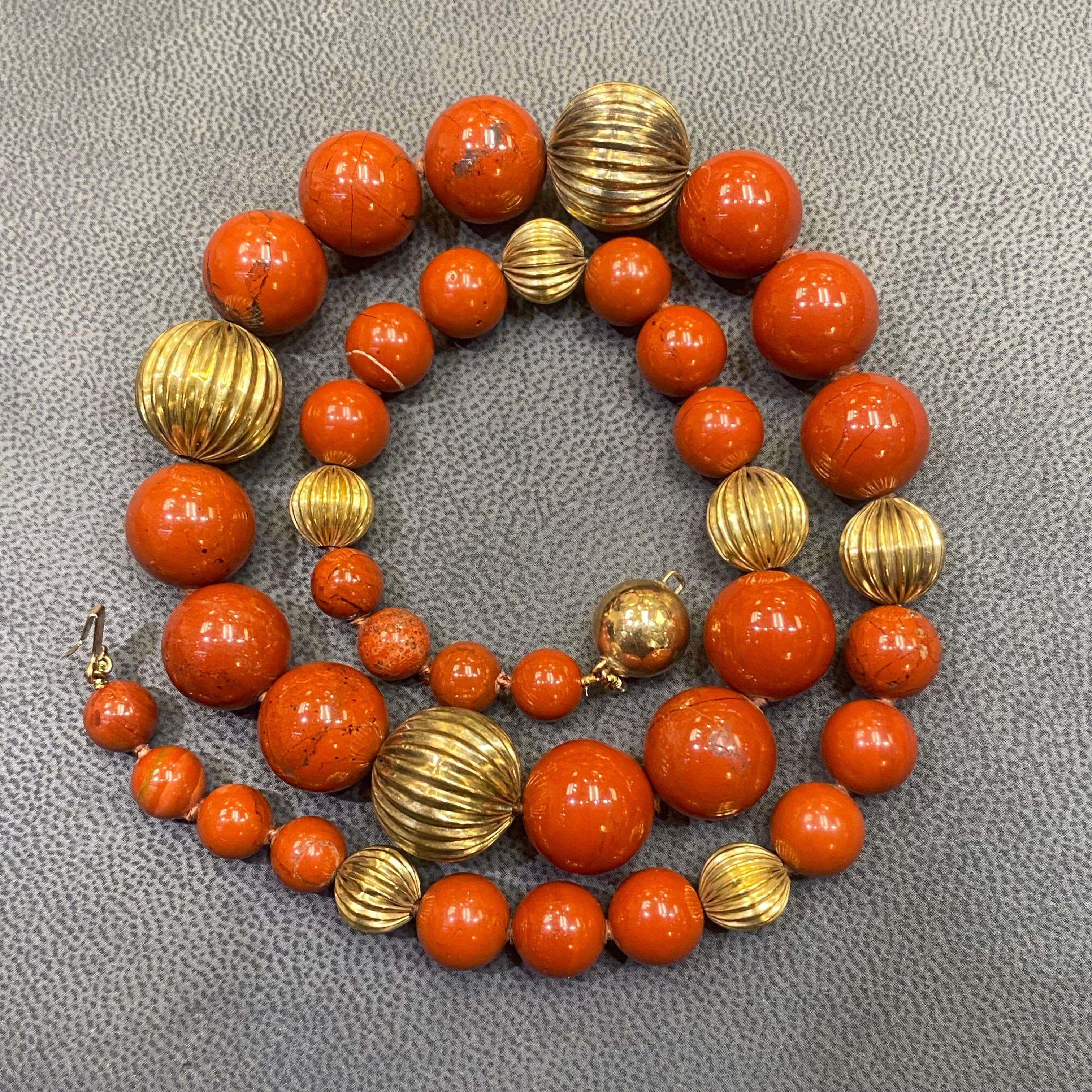 Collana di corniole e perline d'oro. 

A  collana con perle di corniola graduate e nove perle d'oro a coste con chiusura a sfera in oro.

Misure: 20