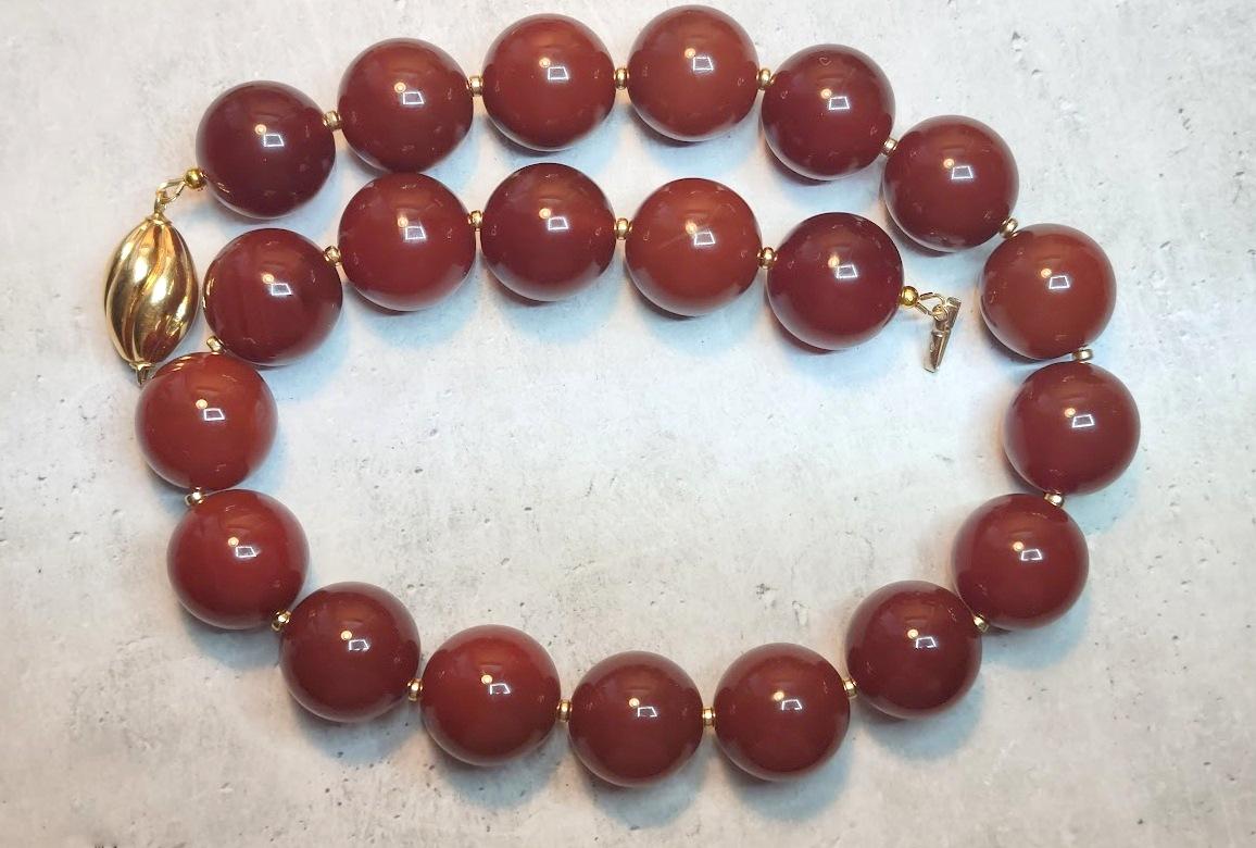 The length of the necklace is 18.5 inches (47 cm). The size of one large smooth, round bead is 20 mm.
Beads are warm, reddish-brown, and shiny. The color of the beads is uniform, slightly varying from deep to light shades. In bright sunlight, the