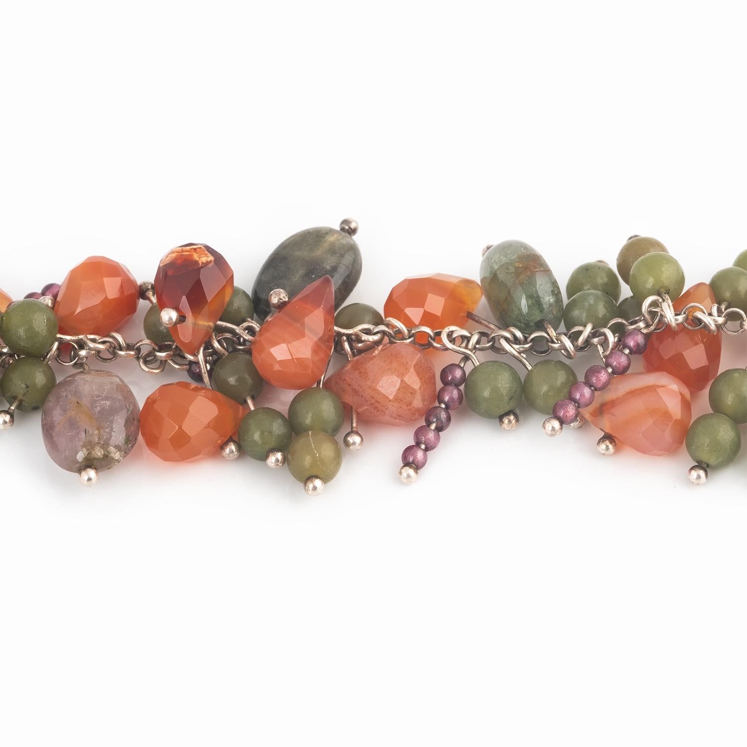 Multi hued gemstones including Tourmaline, Carnelian, Garnet and Apatite are threaded onto sterling silver wire and attached to silver chain with a handmade clasp. A wonderful mix of Fall colors in Oranges, Reds and Greens.
Gemstone beads are mixed