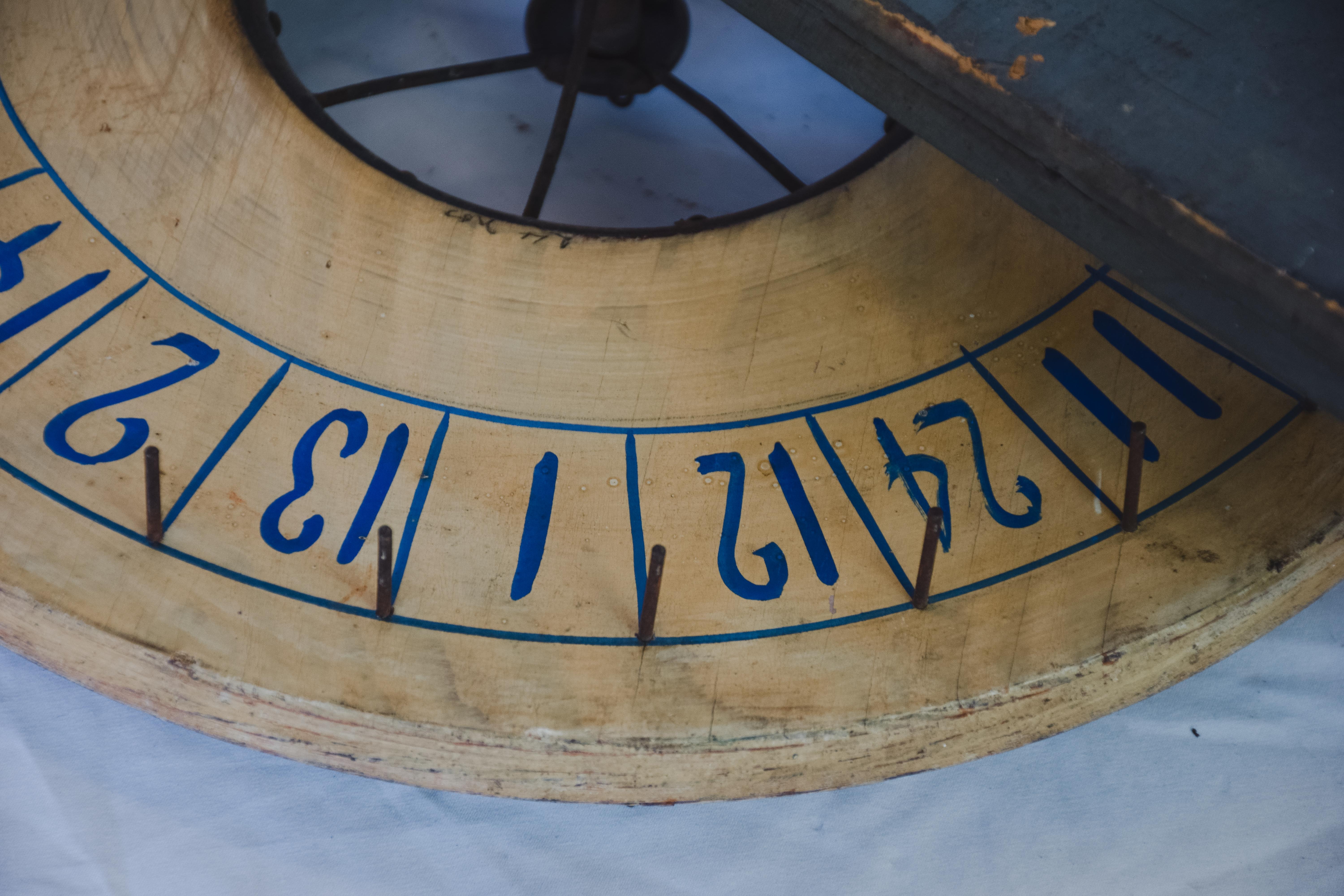 Step right up and take a chance on this vintage carnival game wheel. In really good condition this operational spinning wheel with bright blue numbers, metal dowels and wooden rectangular mount this piece would liven any game room or study