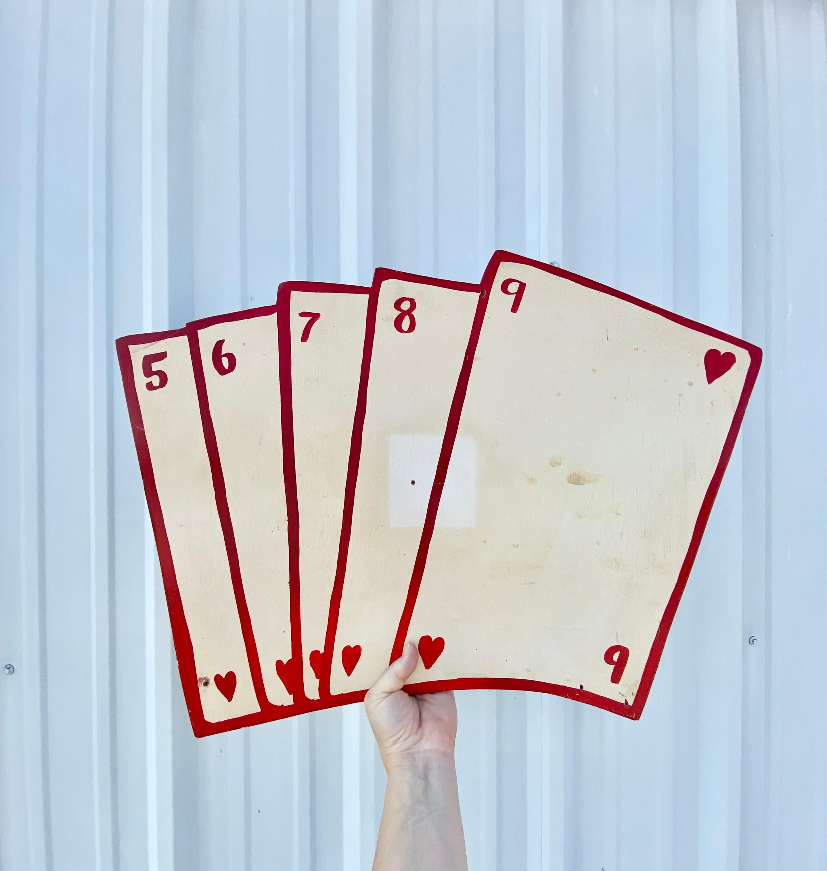 Carte da gioco in legno, stravaganti e intricate, che si ritiene provengano da un vivace carnevale della fine degli anni '70. Questo incantevole pezzo emana un senso di giocosa nostalgia, realizzato per catturare lo spirito festivo della fine degli