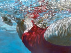 „Cerulean“-Frau in rotem Badeanzug schwimmt auf der Oberfläche des leuchtend blauen Wassers