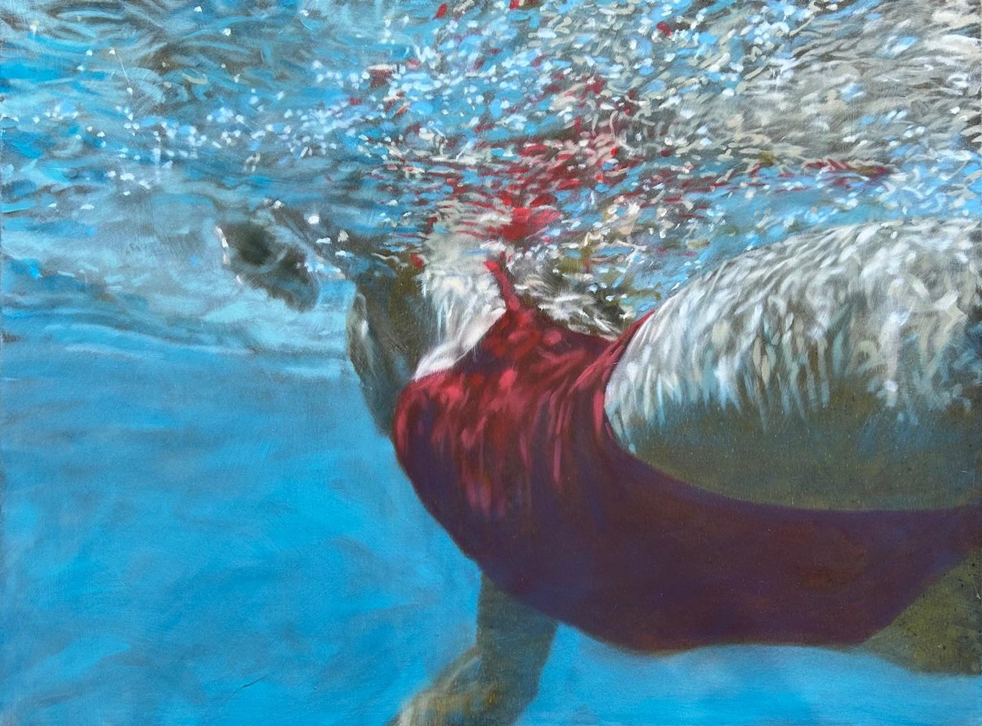 La donna "Cerulea" in costume da bagno rosso nuota in superficie nell'acqua blu brillante
