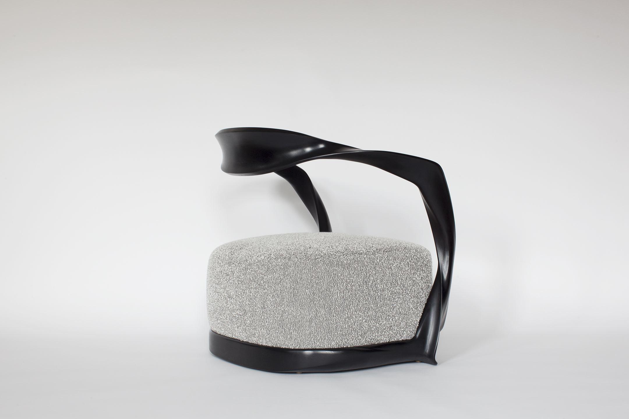 Ce fauteuil sculptural sculpté à la main fait partie d'une gamme de meubles contemporains conçus en associant la technologie numérique à un artisanat traditionnel de qualité. Le fauteuil est doté d'un large dossier en porte-à-faux, ainsi que