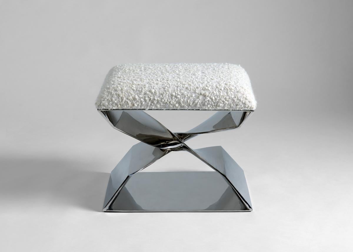 This sculptural stool is part of a line of contemporary furniture designed by blending digital technology with fine traditional craftsmanship. Cast in stainless steel, the stool features two crisscrossing buttresses that twist 180 degrees to engage