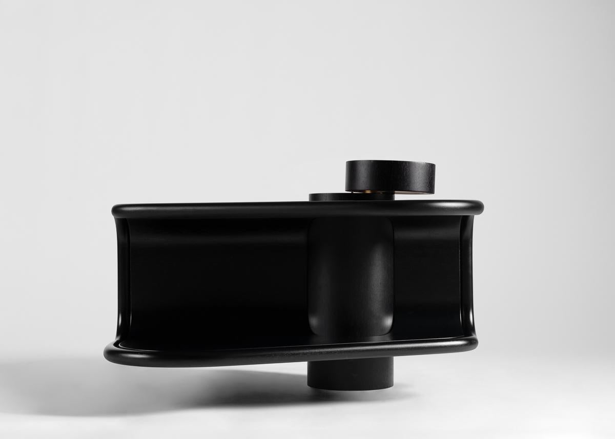 This sculptural coffee table is part of a new line of contemporary furniture designed by blending digital technology with fine traditional craftsmanship. Carved from several pieces of ebonized wood, this piece boasts two tiers, extending out from