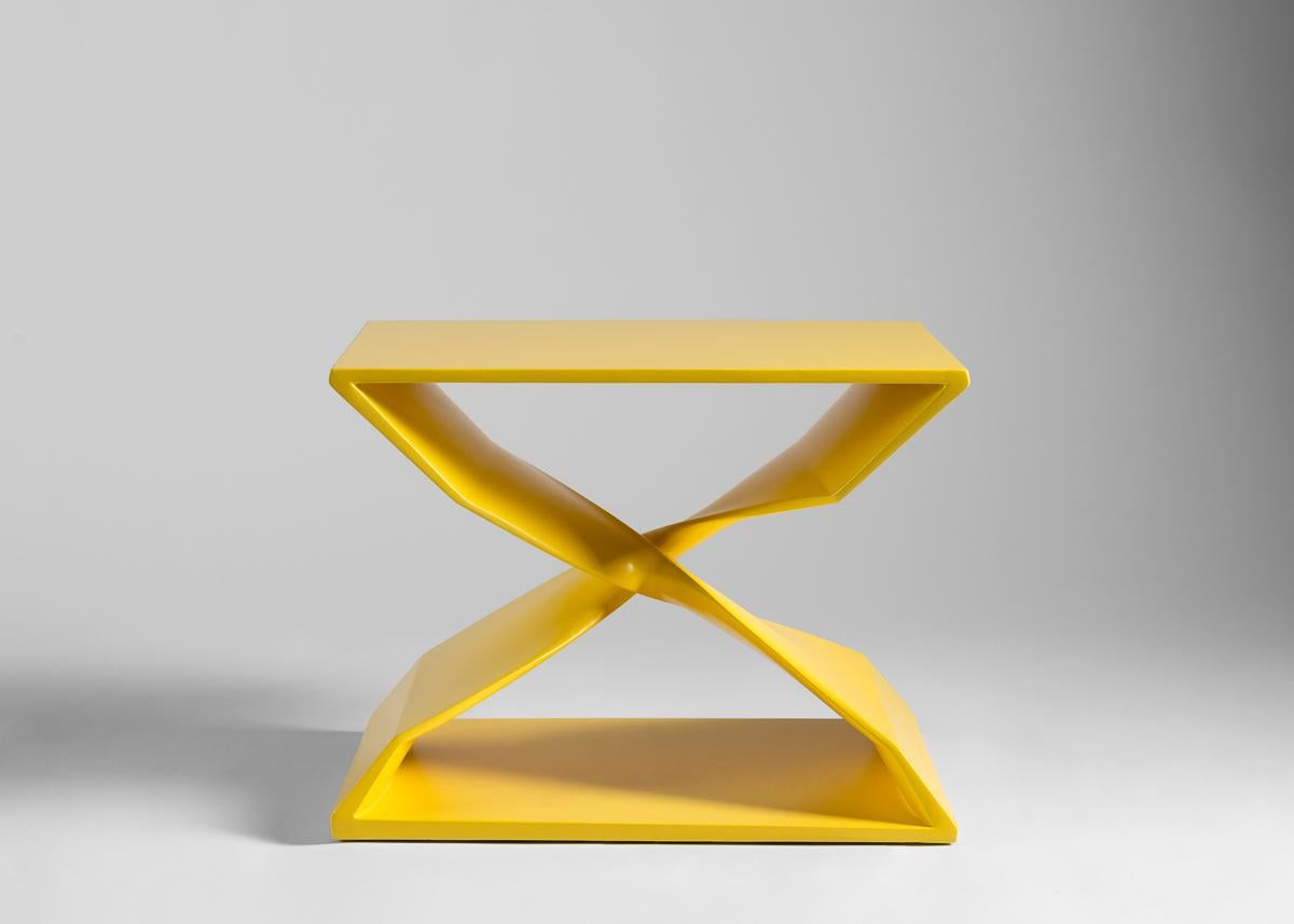 This sculptural hand carved stool is part of a line of contemporary furniture designed by blending digital technology with Fine traditional craftsmanship. The stool features two crisscrossing buttresses that twist 180 degrees to engage in dance that