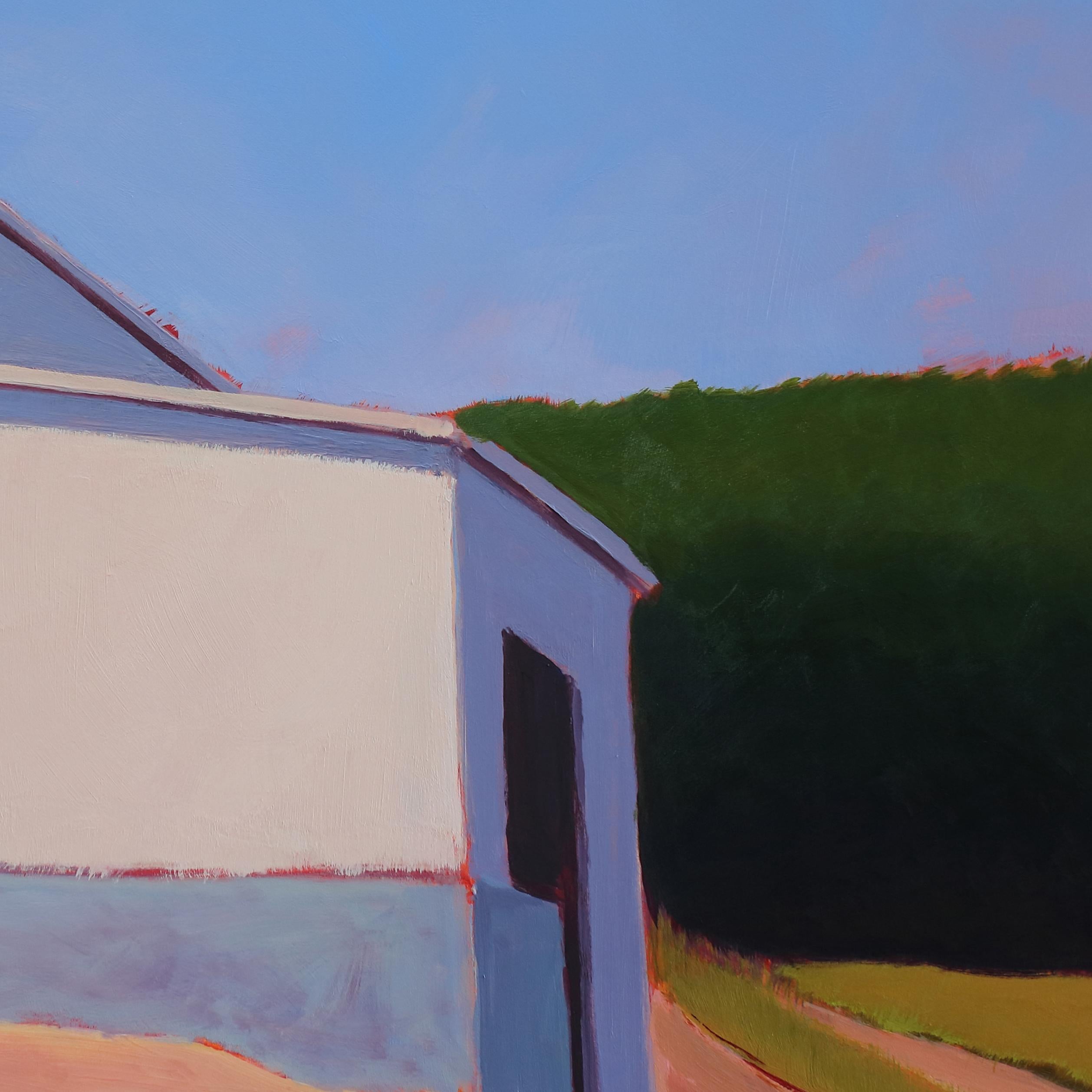 This contemporary landscape painting by Carol Young captures a warm white, barn-like building in a countryside setting. The building is built into a small hill, which is covered in green grass and patches of warm-toned dirt. A line of deep green