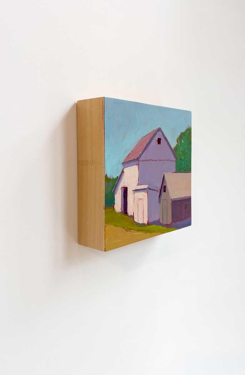 This small contemporary barn painting by Carol Young features a vibrant palette, capturing two warm-toned barns beneath a painterly blue sky and green foliage. The painting is made on board with clean, exposed wood sides, and is ready to hang.