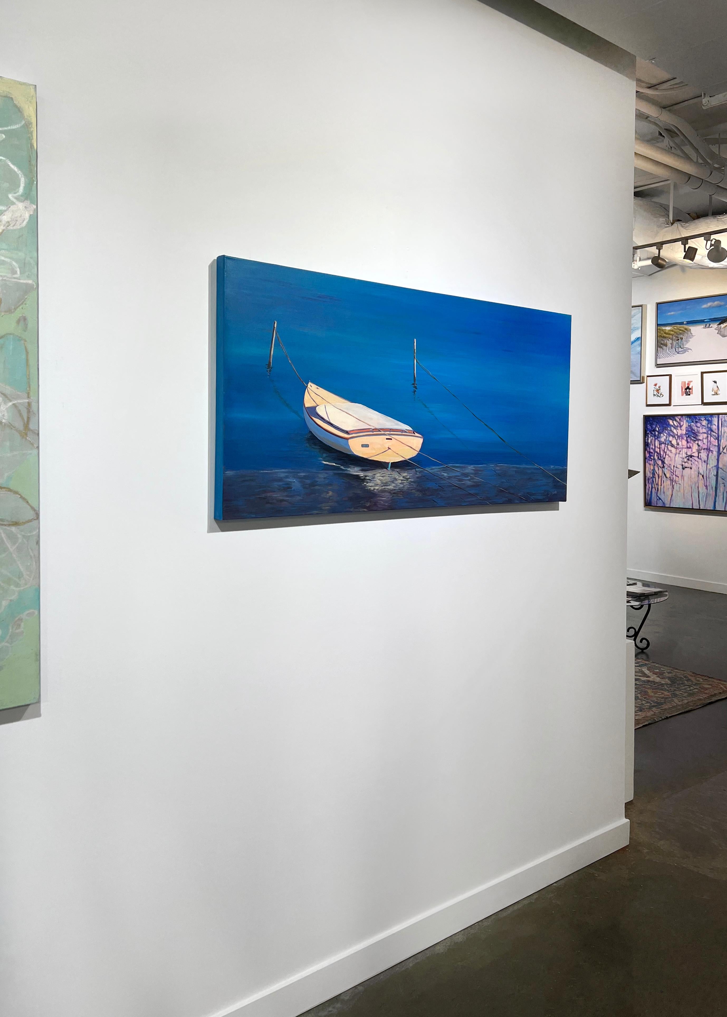 This original contemporary coastal painting by Carol Young features a cool blue palette. It captures a warm, creme-colored dinghy boat docked along a shallow shore, surrounded by vibrant, reflective blue water. It is made with acrylic on gallery