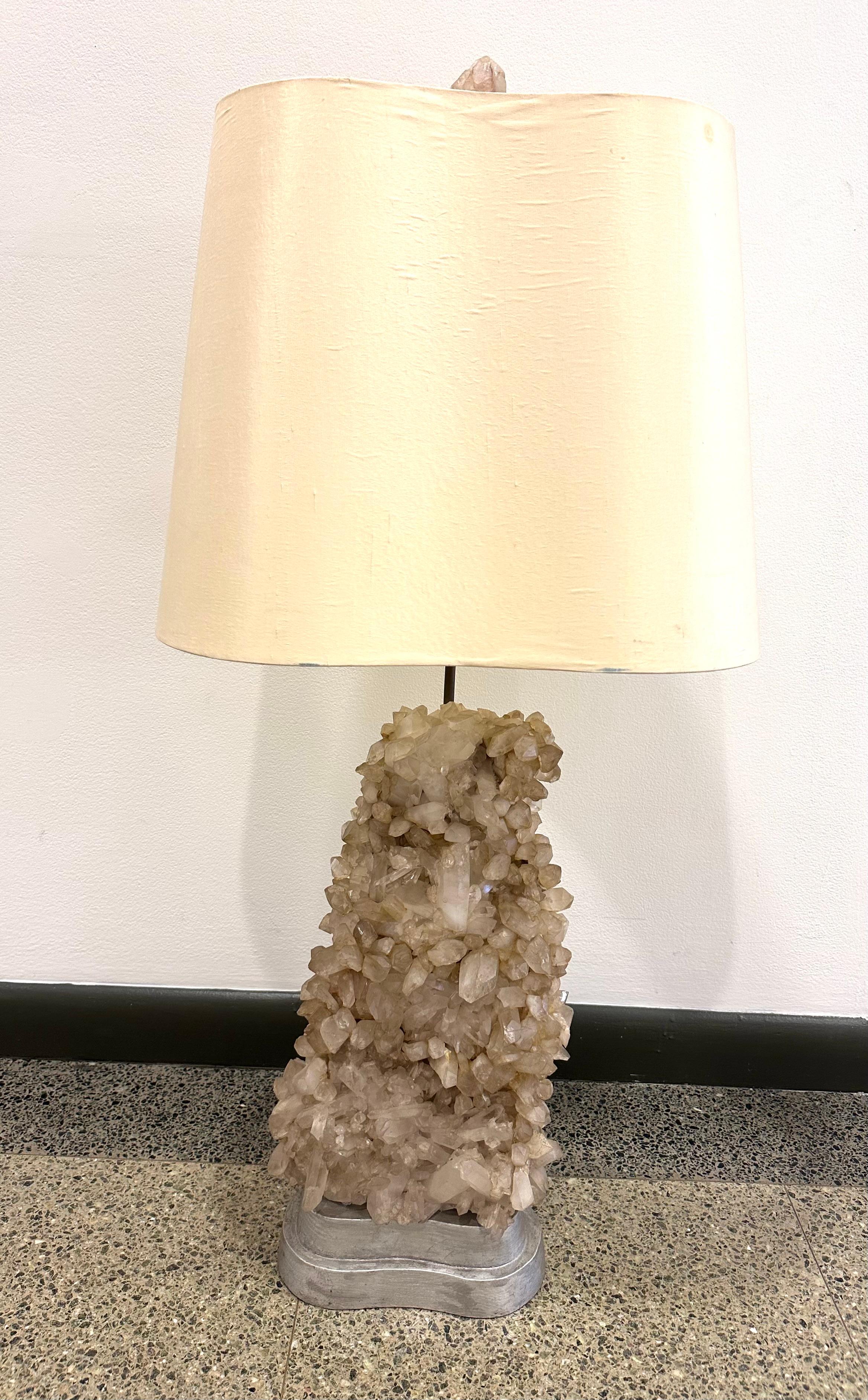 Large example of Carole Stupell's classic studio-made table lamp. The natural Quartz crystal rests on a two-tier bean-shaped silvered wood base. 

The original custom shade mirrors the base form, and is topped with a crystal finial. Crystal is 18