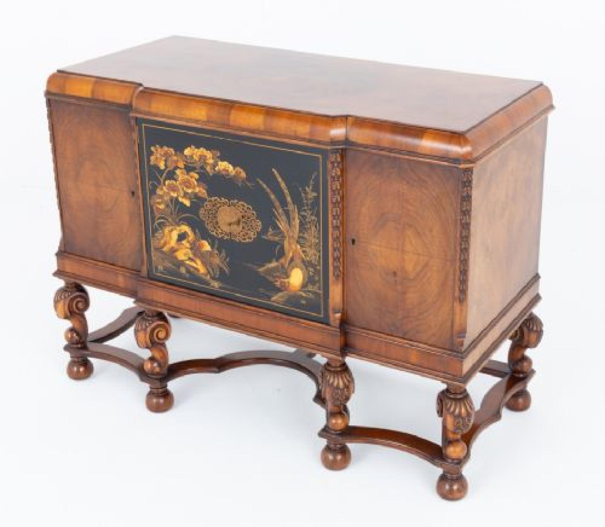 This sideboard stands upon bun feet with a shaped stretcher and typical Carolean shaped and carved supports
Circa 1920
The sideboard features 4 doors, the 2 central doors having wonderful chinoiserie panels and a decorative brass escutcheon
The