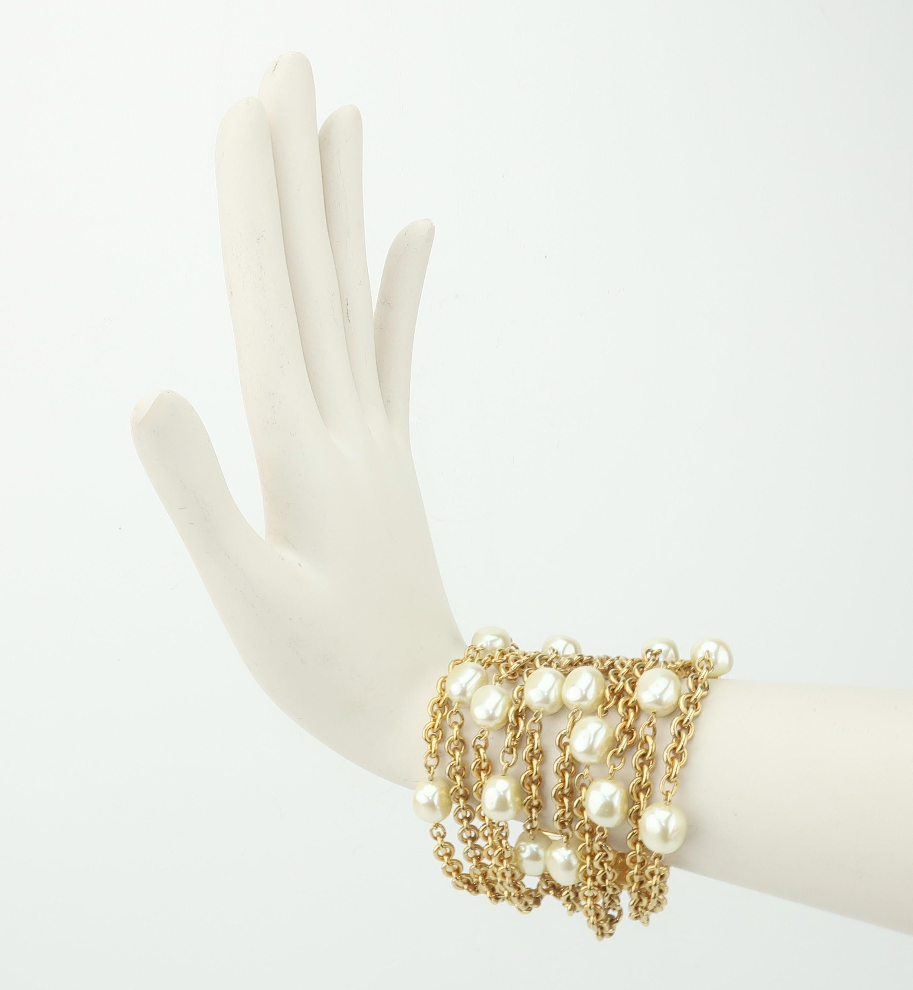 Carolee has been a trendsetting costume jewelry company since the 1970’s.  This 1980's chunky gold tone multi chain bracelet is accented by large faux pearls creating a stylish statement ... with a nod to Chanel designs.  The bar slide clasp has a