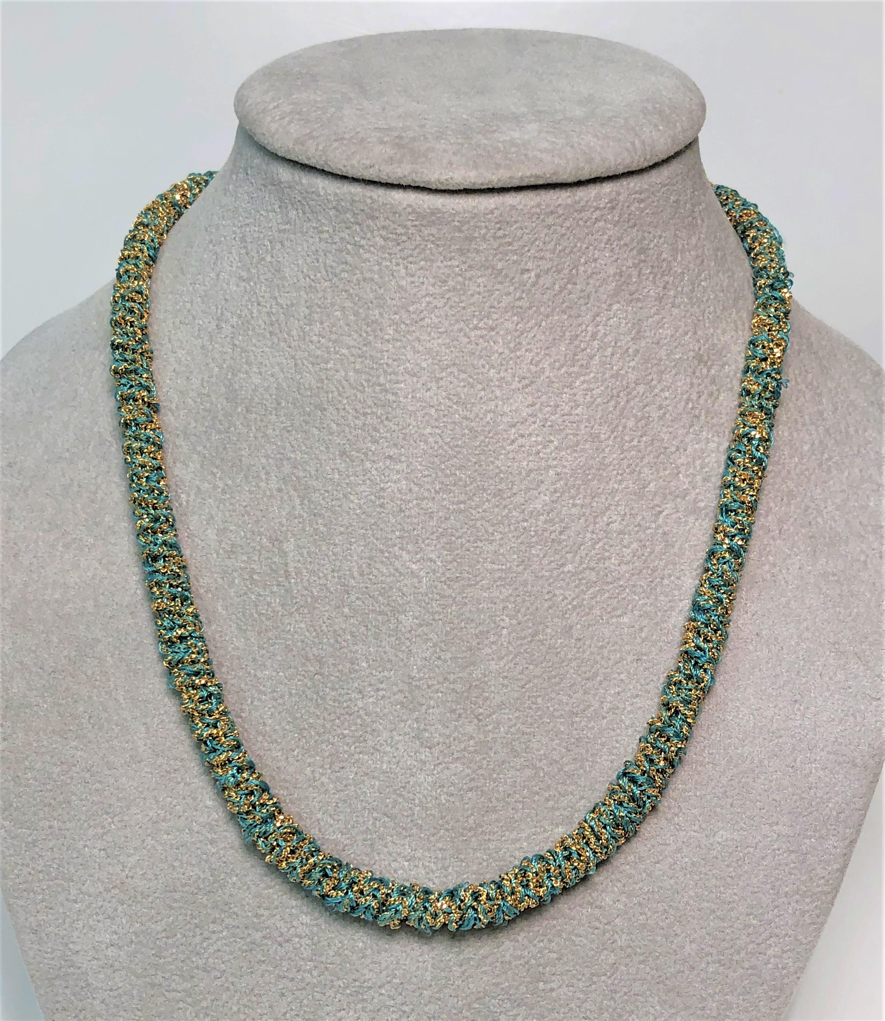 From designer Carolina Bucci, her design style really shows in this beautiful, easy to wear necklace.  
It can also be worn as a bracelet for a different look!
This has never been worn!
18 karat yellow gold woven with a turquoise color fabric.
18