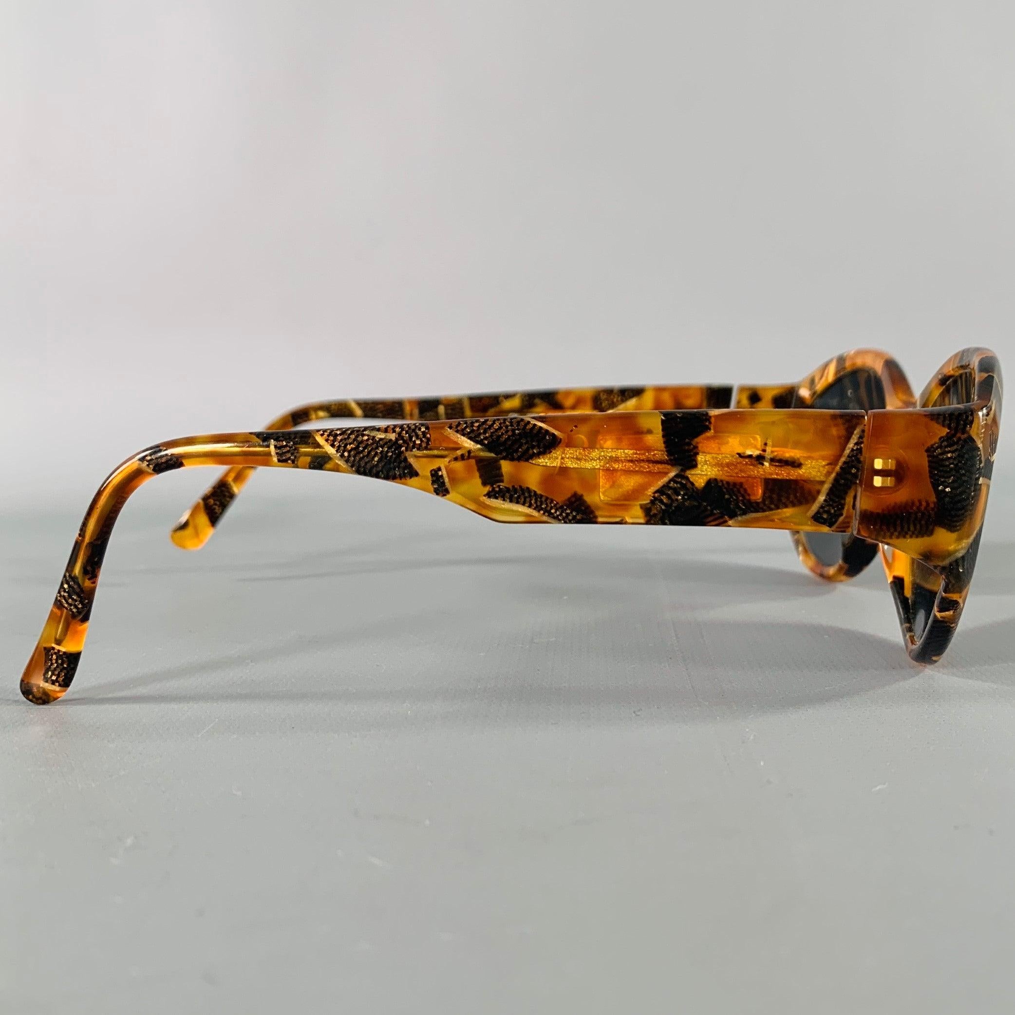 CAROLINA HERRERA sunglasses frames
in a brown and beige acetate featuring a tortoiseshell pattern and oval shape. Handmade. Note: these frames contain corrective lenses, which will need to be changed by an optician before wear.Very Good Pre-Owned