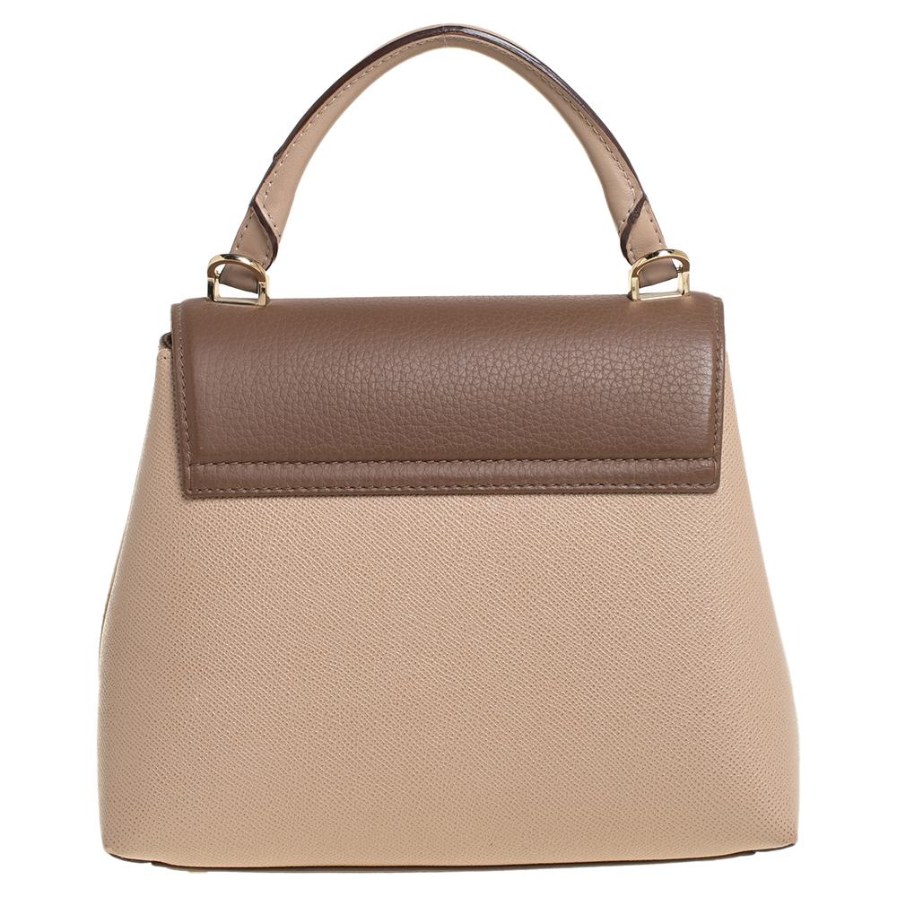 This bag from Carolina Herrera is classy, chic, and effortlessly stylish! It has been crafted from monogram-embossed leather and designed with a front flap that carries a gold-tone push lock. It is held by a top handle and opens to an interior that