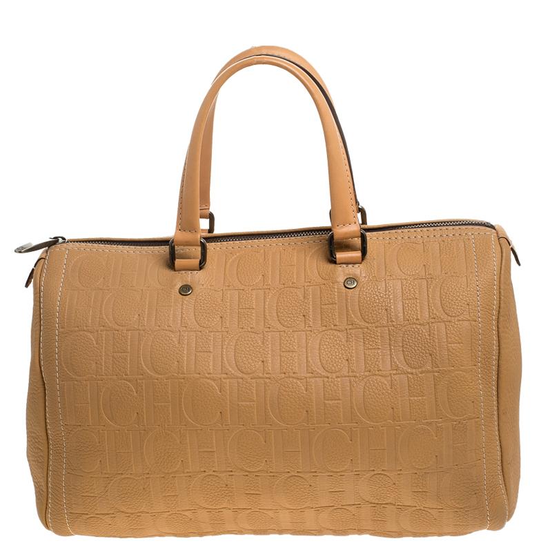 Este bolso Andy Boston de Carolina Herrera, una pieza realmente elegante para añadir a tu colección, está confeccionado en piel beige y decorado con cuidados detalles de pespuntes. Presenta un cierre superior de cremallera, dos asas, pies metálicos