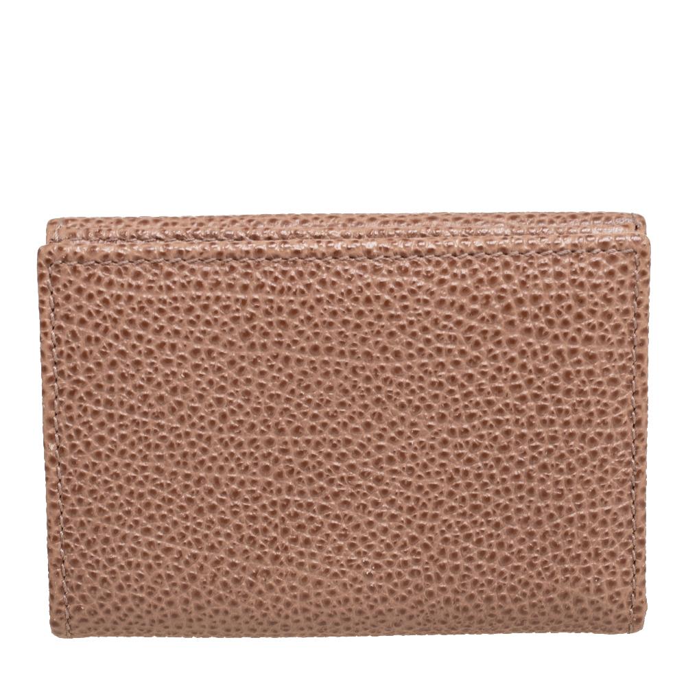 Crafted using beige textured leather, this wallet from Carolina Herrera features the signature CH logo at the front and comes with lined slots. It can easily hold your cards and cash in an organized manner. Slip it into your everyday tote.

