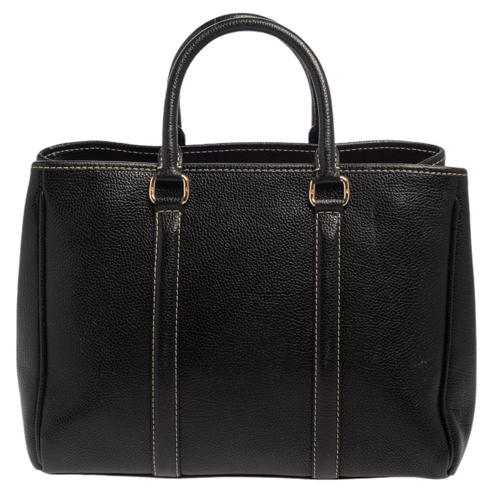 Skillfully designed, this Matteo tote from Carolina Herrera is an all-time favorite. It is made from grained leather and comes in a lovely black shade. The beauty of the bag is enhanced with signature details on the front and gold-tone accents. It