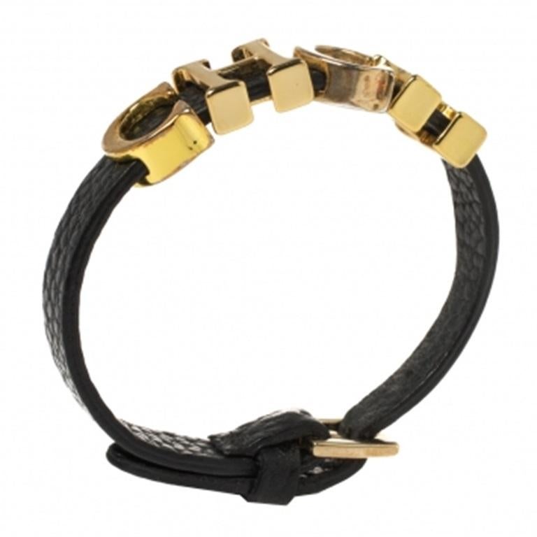 This beautiful bracelet by Carolina Herrera is designed with four gold-tone CH sliding charms woven in black leather. It features an adjustable buckle closure with adjustment holes.
