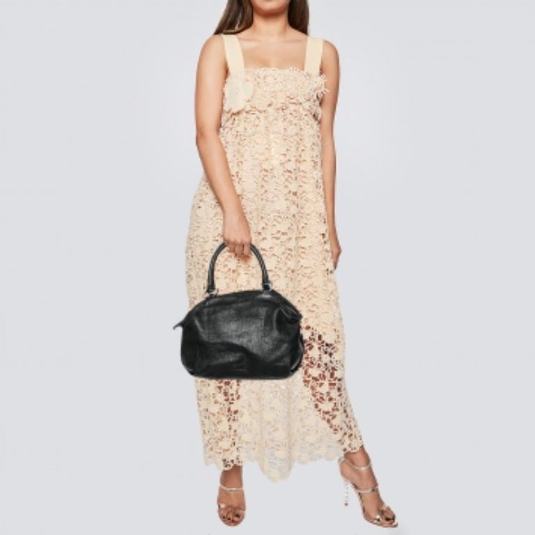 Diese schwarze Version der Carolina Herrera Tasche ist aus Leder mit Monogrammprägung gefertigt. Sie ist mit zwei Griffen, einem Reißverschluss an der Oberseite und goldfarbenen Beschlägen ausgestattet. Der Innenraum aus Stoff ist geräumig genug, um