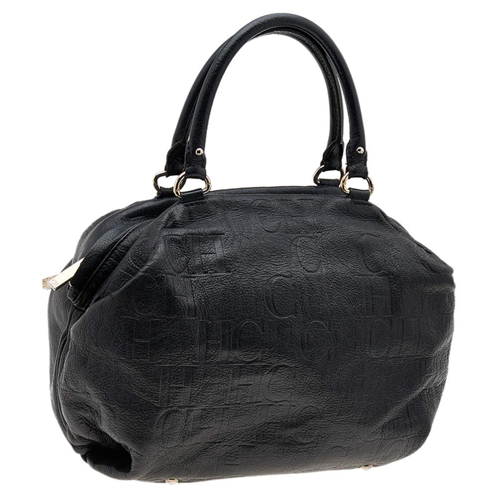 Diese schwarze Version der Carolina Herrera Tasche ist aus Leder mit Monogrammprägung gefertigt. Sie ist mit zwei Griffen, einem Reißverschluss an der Oberseite und goldfarbenen Beschlägen ausgestattet. Der Innenraum aus Stoff ist geräumig genug, um