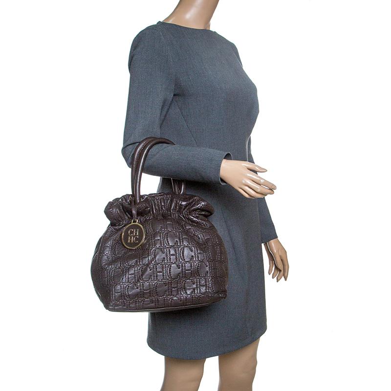 This tote from the house of Carolina Herrera will make a fine addition to your closet. Crafted from monogram canvas and styled with leather trims the bag features dual handles. It has a spacious fabric lined interior that houses a zip pocket, and