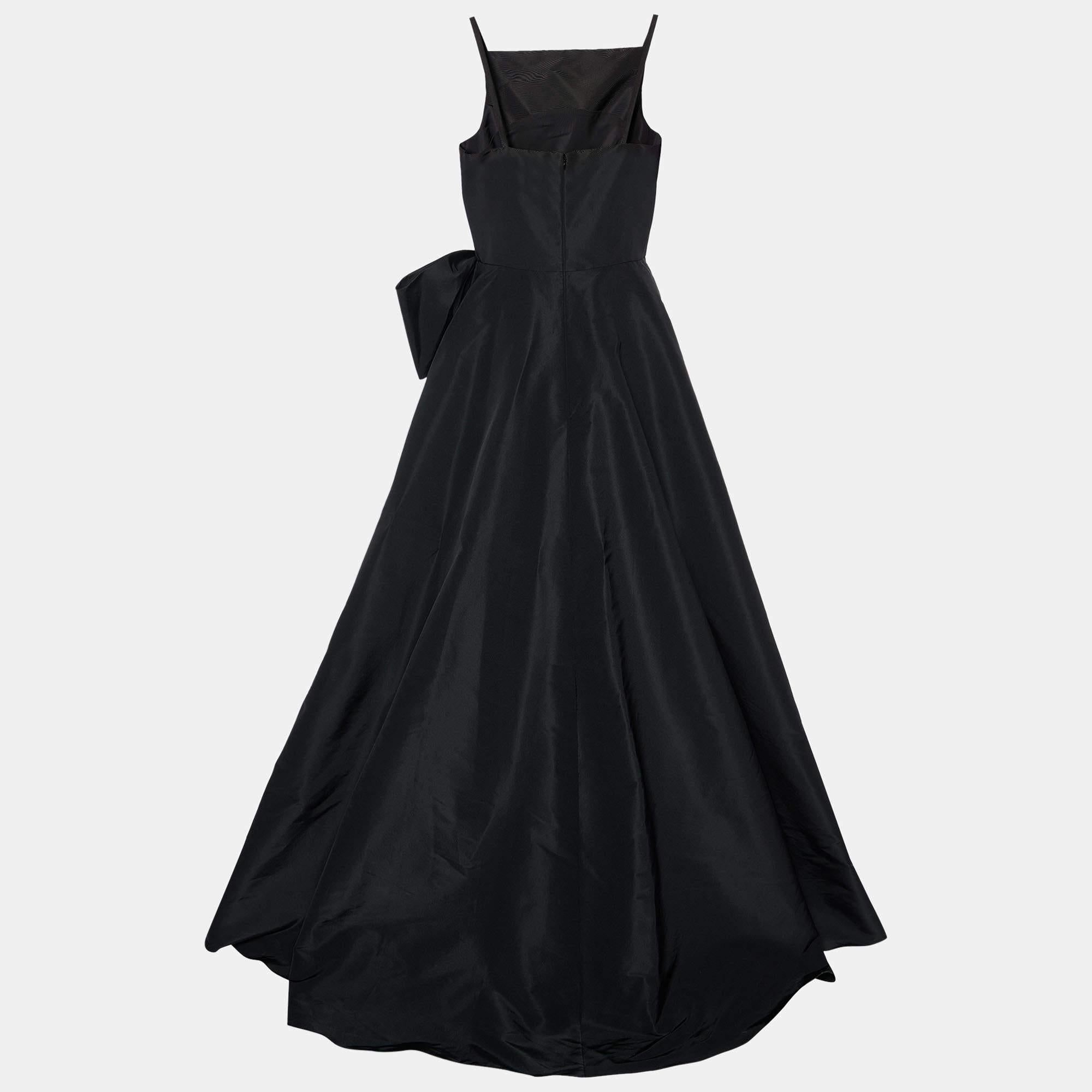 Sway like a dream in this evening gown from Carolina Herrera. Tailored to perfection, the black silk taffeta gown has been draped beautifully and carries a bow detail and a floor-sweeping hemline. Pair it up with simple heels and a statement