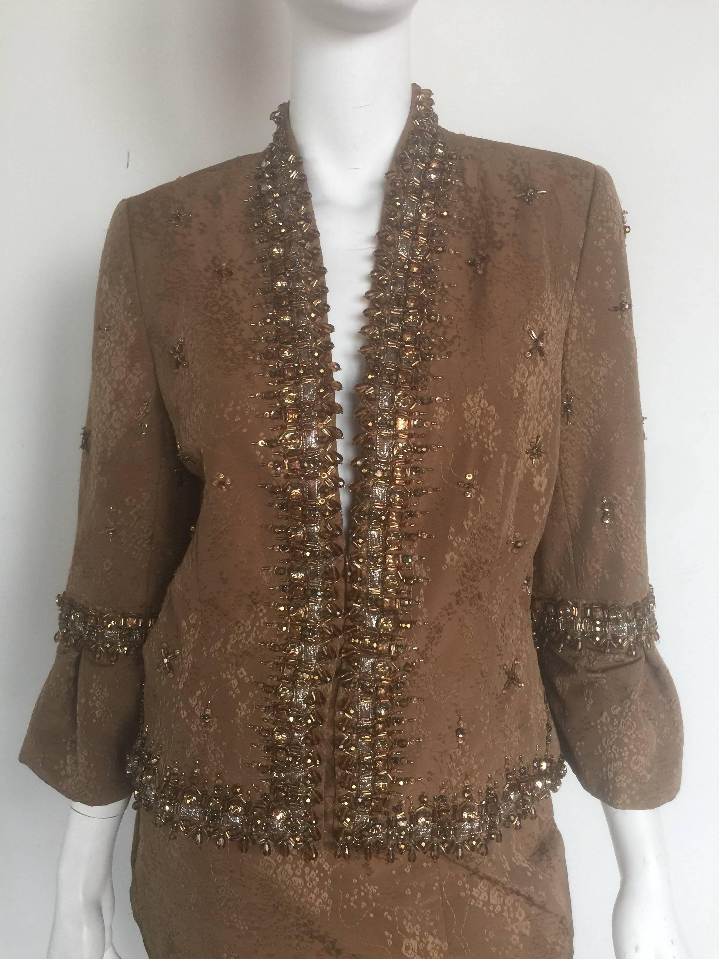This two piece skirt suit is a bronze wool poly blend with beautiful bronze and gold crystal and beading details along the collar sleeves and all over the jacket.  The skirt is a US 10 and the Jacket is a US12.  This is a beautiful set together or
