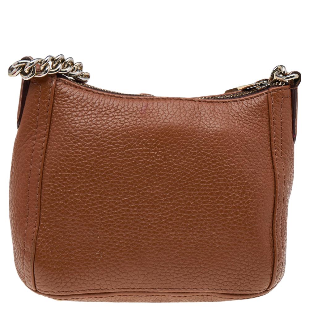 This crossbody bag from Carolina Herrera is delightful and will prove functional to you. It is made from brown leather and comes with a logo embellishment on the front. It has gold-toned hardware, a spacious interior, and a shoulder strap. Take this