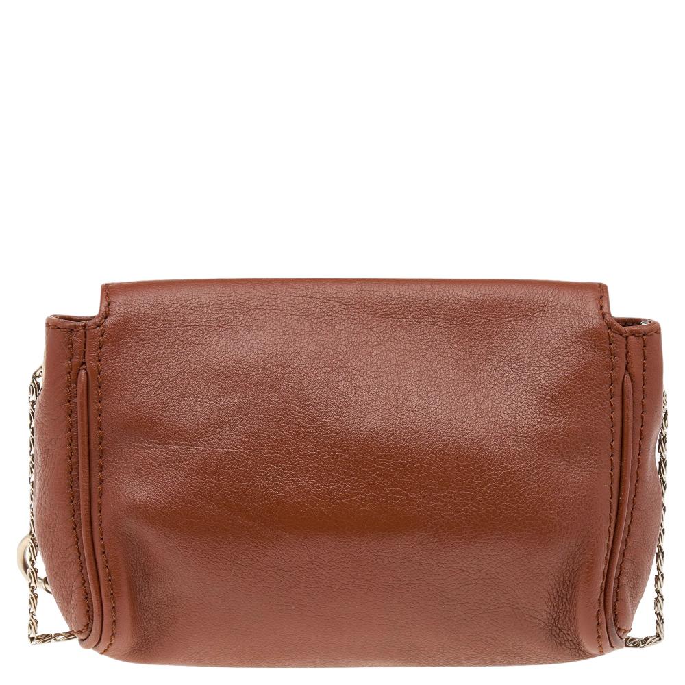 The house of Carolina Herrera has exclusively designed this elegant bag for you. It has been crafted from brown leather and adds a chic appeal to any ensemble. It has a front flap with the 'CH' logo that opens to a fabric-lined interior. It is