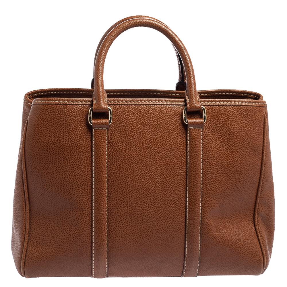 Skillfully designed, this Matteo tote from Carolina Herrera is an all-time favorite. It is made from leather and comes in a lovely brown shade. The beauty of the bag is enhanced with signature details on the front and gold-tone accents. It comes