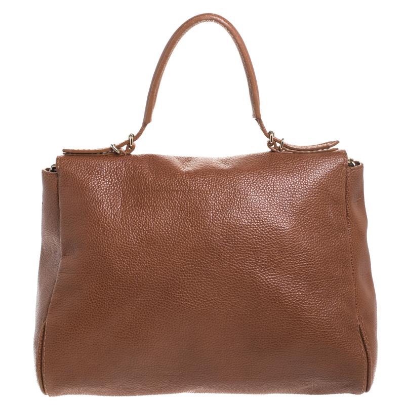This practical and stylish bag from the luxury brand Carolina Herrera is crafted in brown leather. It features a front flap detailed with the brand logo in gold-tone hardware. The bag comes equipped with a single handle and a chain link shoulder