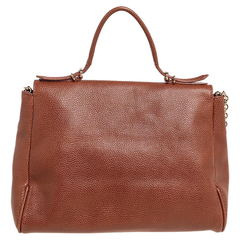 This Minuetto bag from the house of Carolina Herrera is something you would go to season after season. It has been crafted from leather into a flap style. It comes with a chain shoulder strap in addition to a flat top handle. It has a subtle slouch