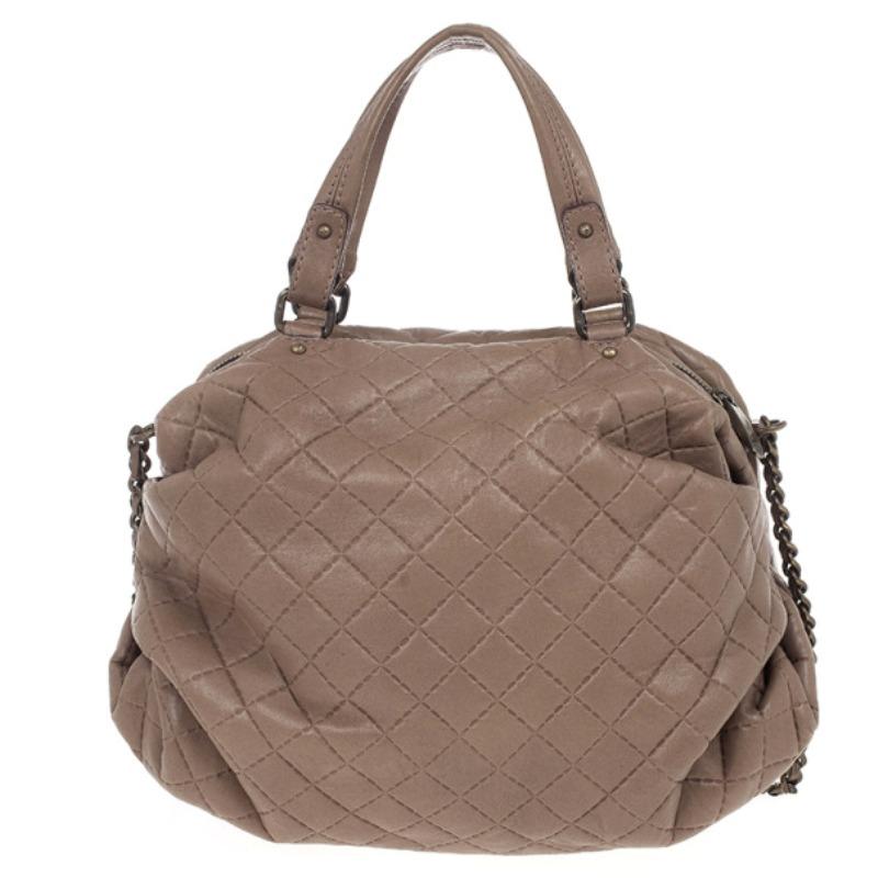 Add a touch of lady-like polish to a look with this Brown Quilted Convertible Tote. This Carolina Herrera tote is crafted from quilted brown leather and features double chain-link and leather handles. It is accented with a front Carolina Herrera