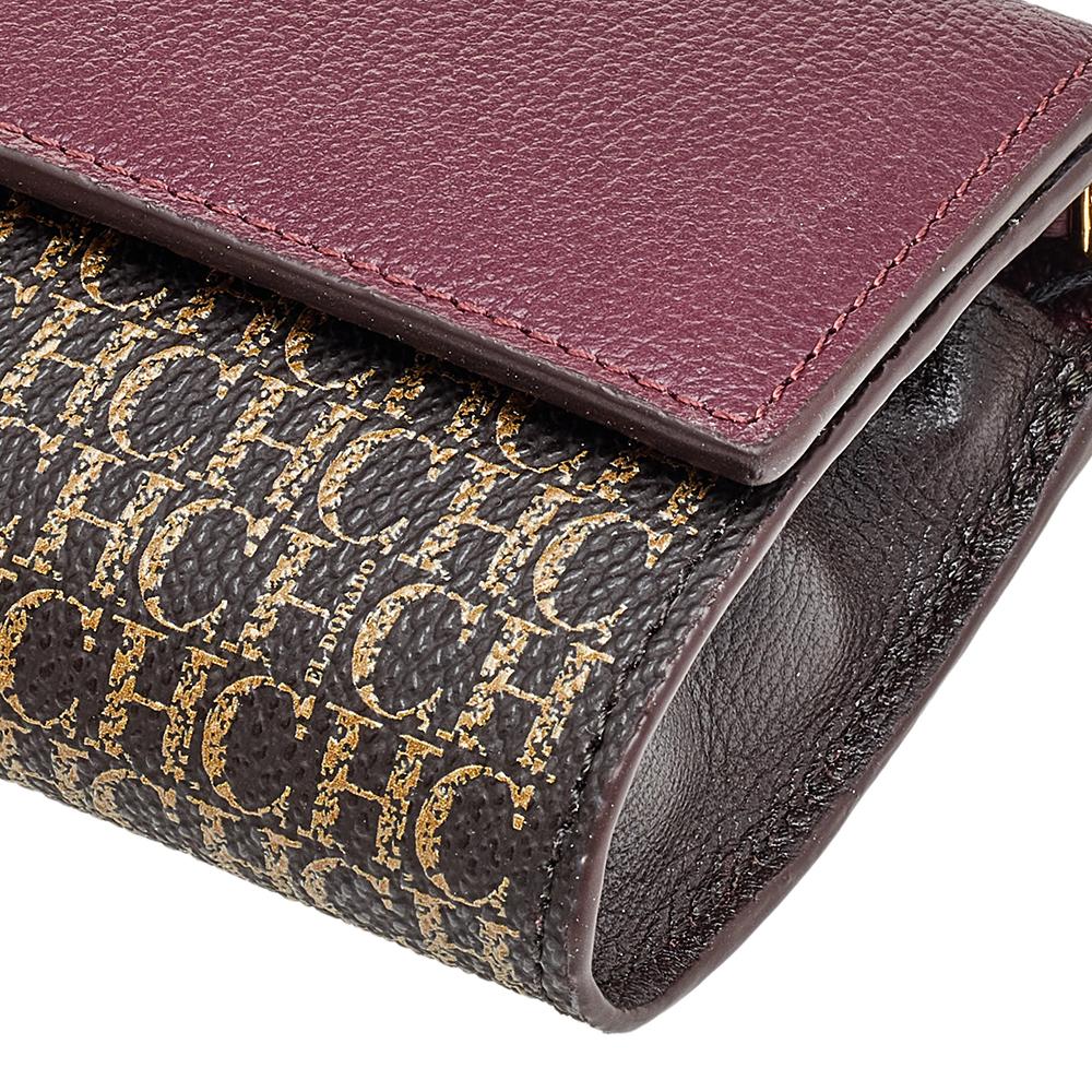 This wallet on chain from the House of Carolina Herrera is a functional and luxurious accessory that will definitely elevate your style. It is made from burgundy-brown PVC and leather with a gold-toned logo motif attached to the front. It has a