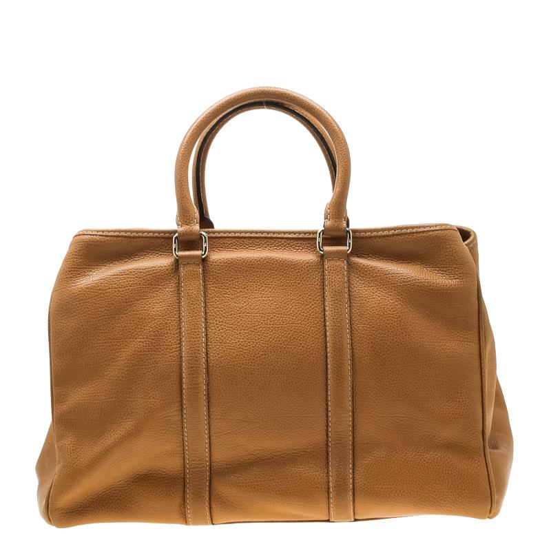 Crafted by the finest Carolina Herrera's Matteo tote lives up to its reputation. The brown exterior is covered in leather and the bag comes with dual top handles. The tote has an open top that leads to a fabric lined interior housing a zipped