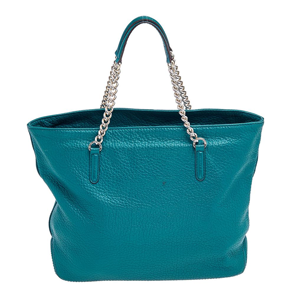 This luxe and chic tote by Carolina Herrera is crafted from green leather and accented with gold-tone hardware. It is designed with chain-link straps and a tassel charm The large fabric-lined interior is ideal for carrying daytime