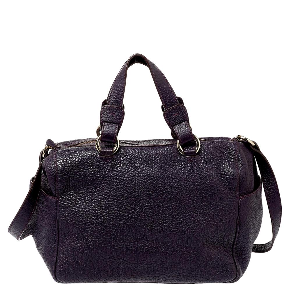 Smart and sophisticated, this Carolina Herrera Boston bag can last you season after season. Crafted from grained leather in a dark purple shade, the bag is equipped with a zip fastening that opens to a generously spaced interior for your