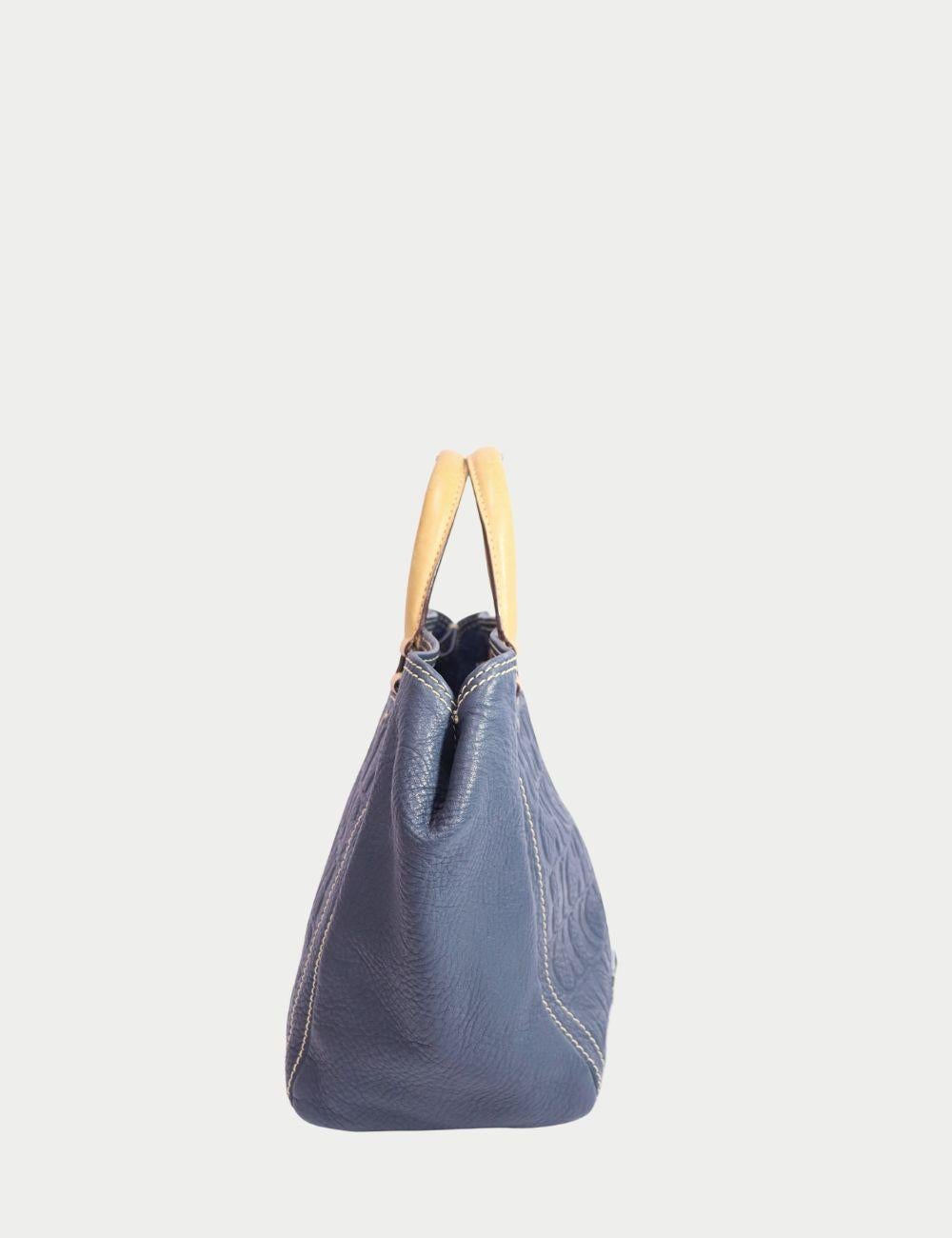 Carolina Herrera - Fourre-tout en cuir bleu marine avec monogramme en relief

Ajoutez une touche de sophistication sans effort à votre look de tous les jours avec cet authentique sac fourre-tout Carolina Herrera Navy. Confectionné en cuir grainé de