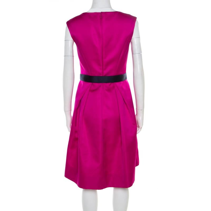 Get set to rock a fashionable outing in this gorgeous dress from Carolina Herrera! The sleeveless fuchsia creation features a fit and flare silhouette. It flaunts a bateau neckline and a contrasting belt on the waist and comes equipped with a
