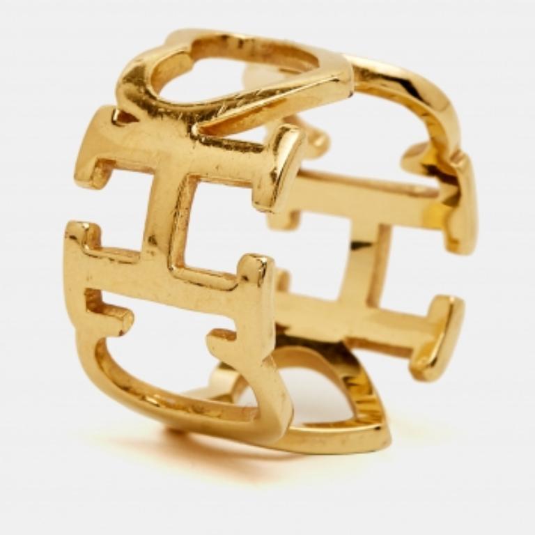 La bague de Carolina Herrera est un accessoire immédiatement reconnaissable. Il est sculpté en métal doré avec le logo CH signature et se termine par des courbes et des lignes douces.