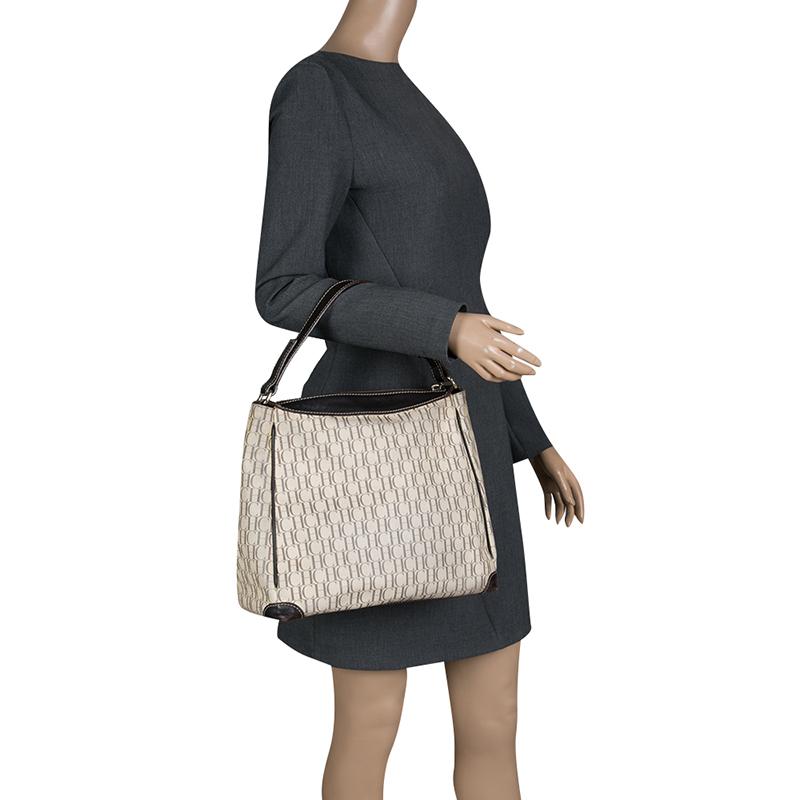 Stylish and classy, this coated canvas and leather bag from Carolina Herrera takes you through your day with ease. It is all you need to go about your day in style and luxury. Complement your clothing by adorning this handbag in beige color, lined