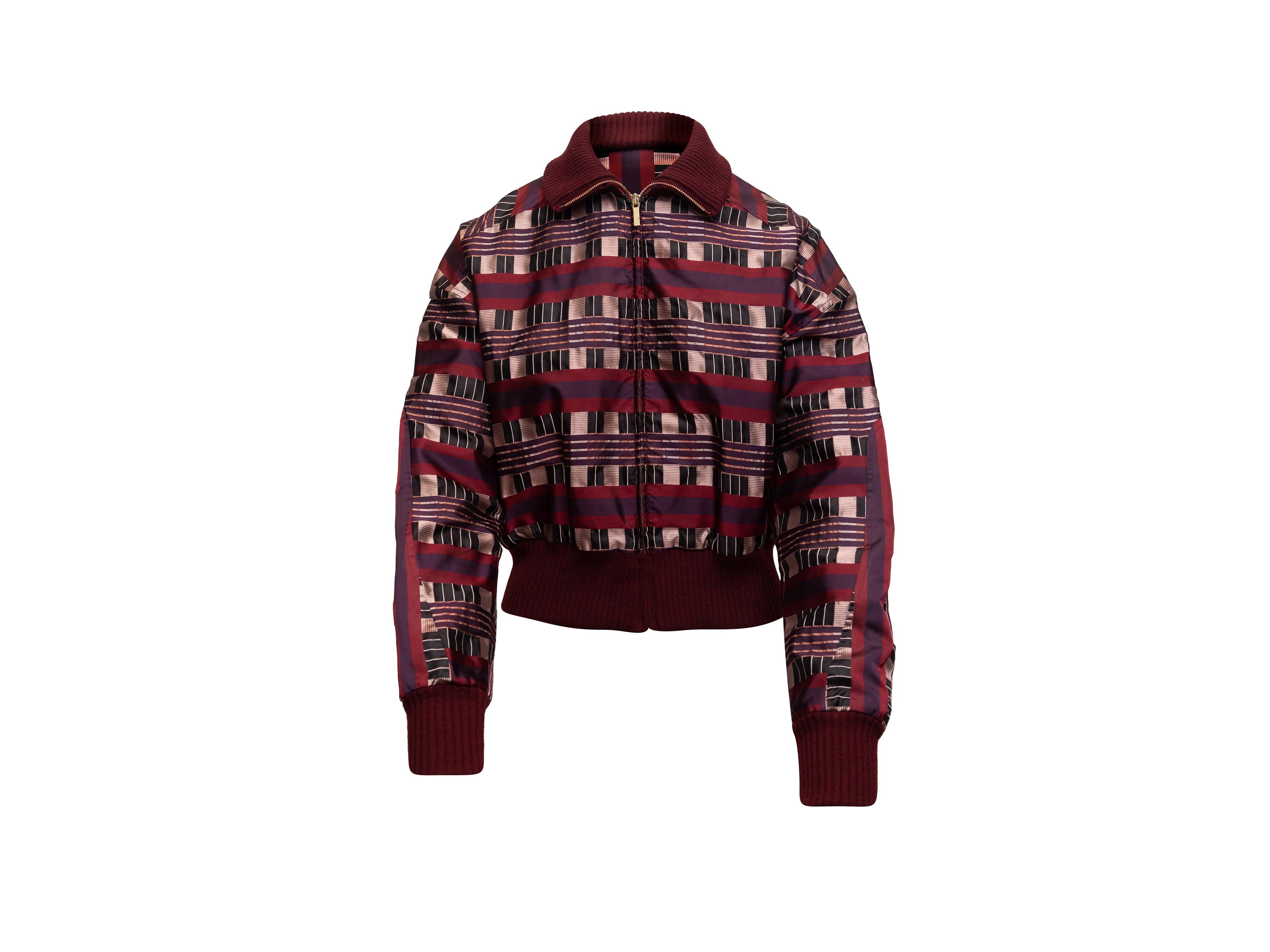 Product details: Maroon and multicolor silk bomber jacket by Carolina Herrera. Geometric pattern throughout. Rib knit trim. Zip closure at center front. 40
